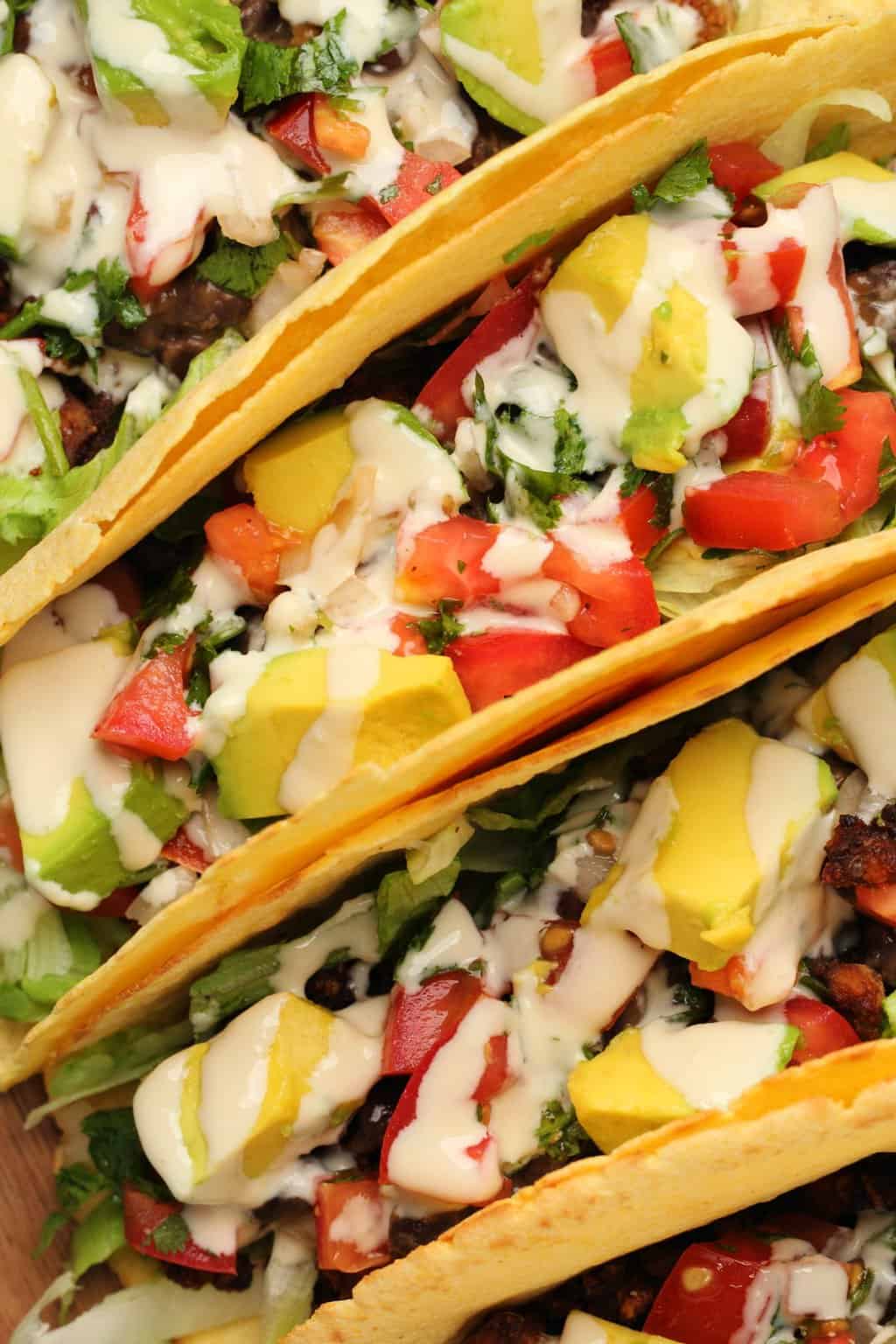 Tacos végétaliens farcis aux haricots noirs, viande taco végétalienne, pico de gallo, avocat et sauce tahini. 