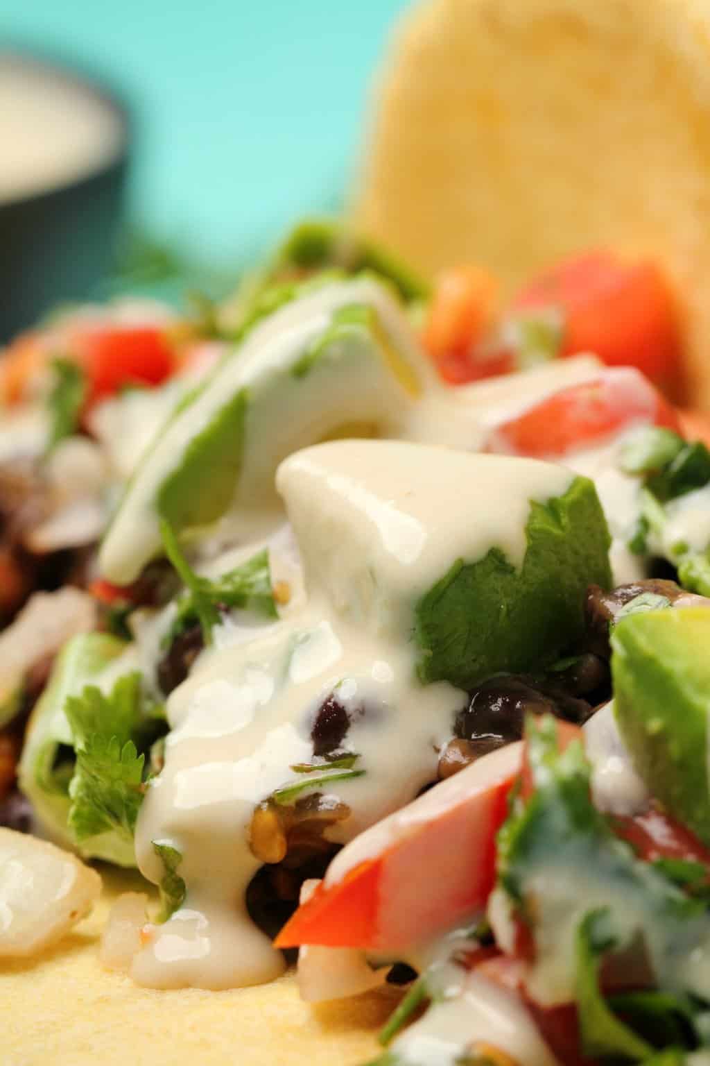 Tacos végétaliens farcis aux haricots noirs, viande taco végétalienne, pico de gallo, avocat et sauce tahini.