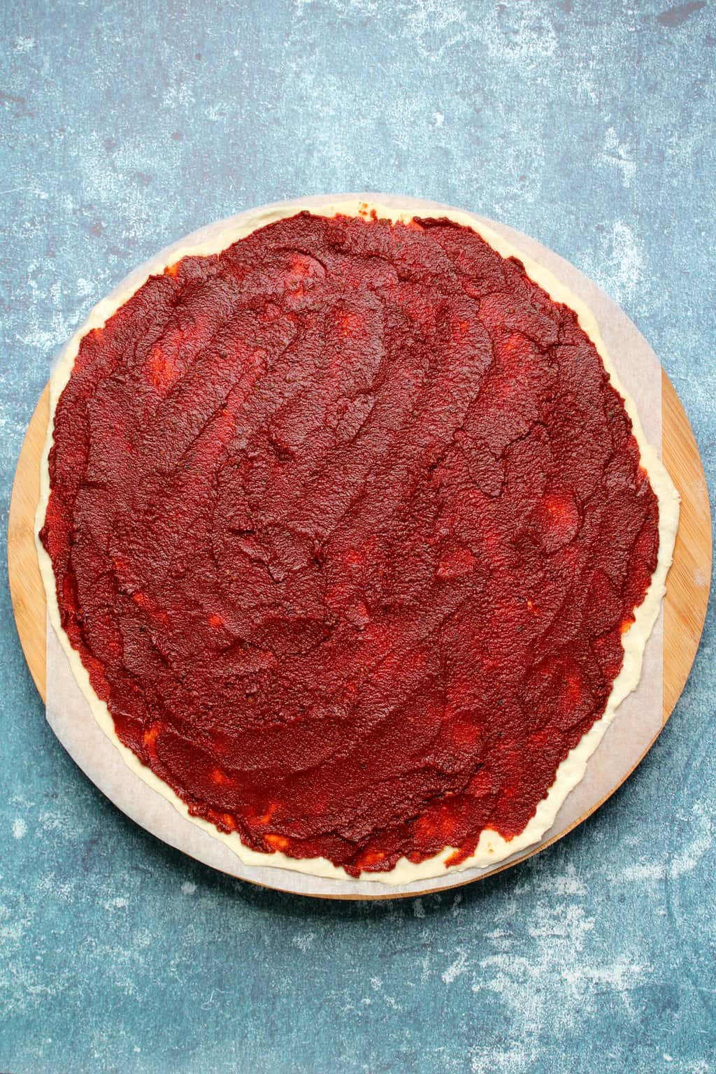 Base de pizza végétalienne non cuite avec sauce tomate. 