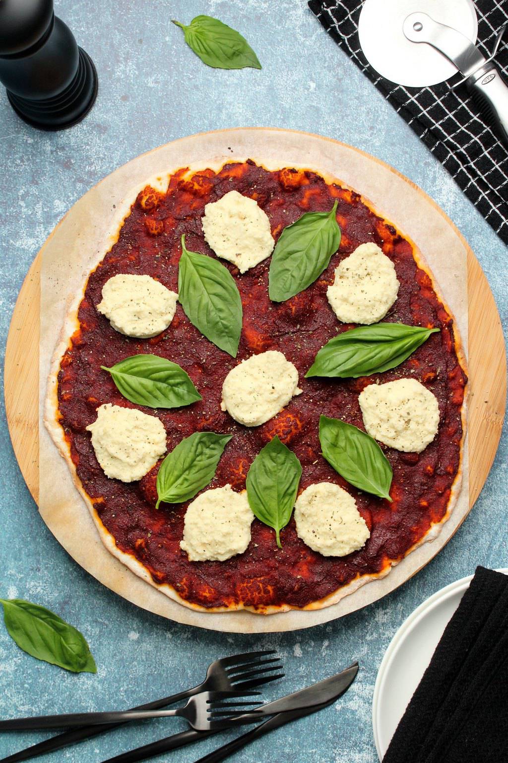 Pizza végétalienne garnie de basilic frais et de ricotta végétalienne. 