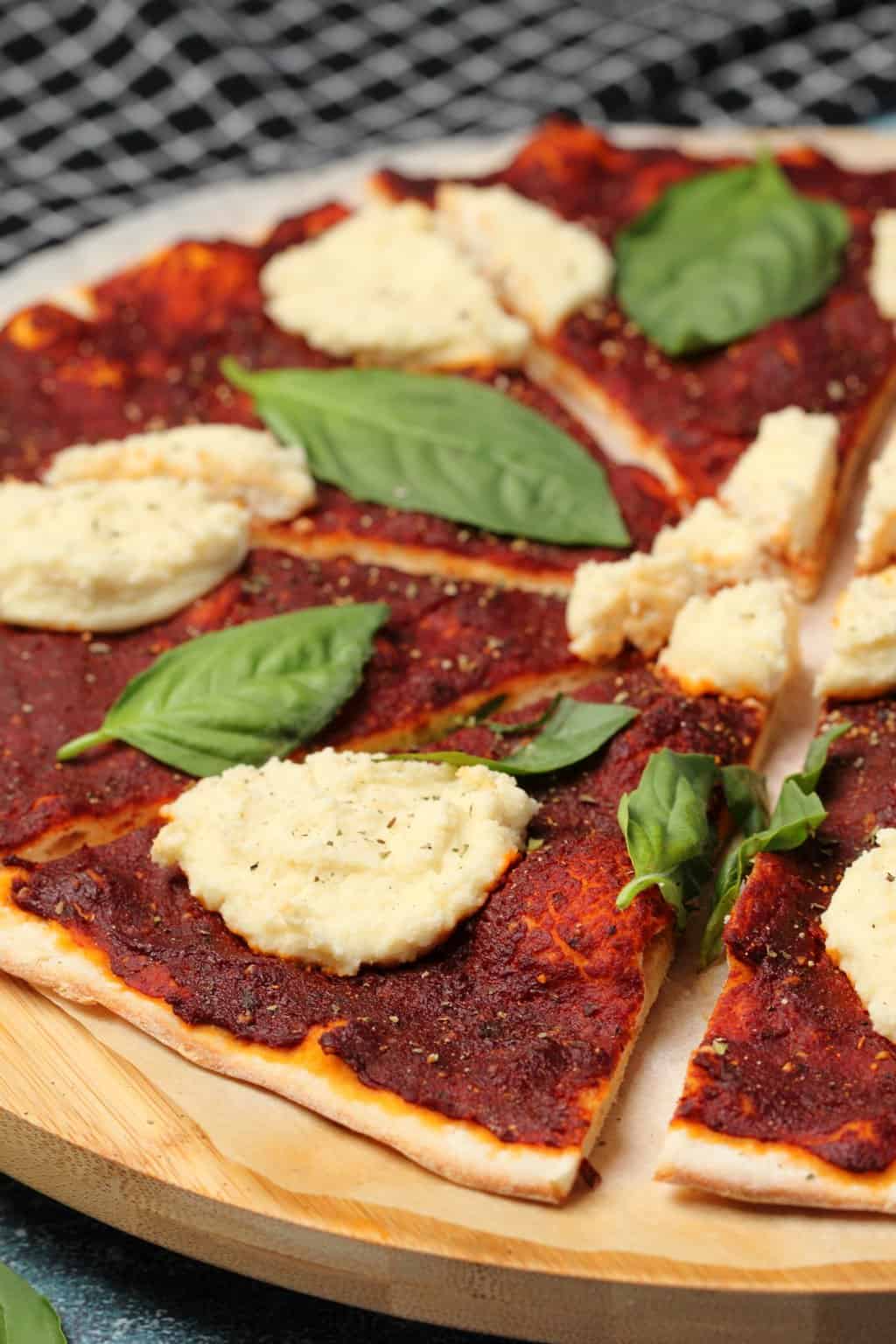 Pizza végétalienne garnie de basilic frais et de ricotta végétalienne. 