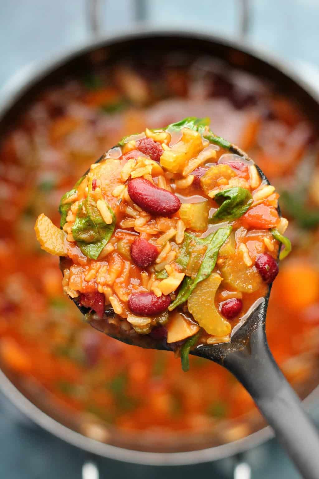 Soupe minestrone végétalienne dans une casserole avec une louche à soupe.