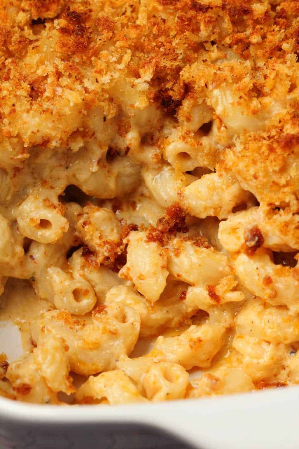 Macaroni au fromage végétalien au four Macaroni végétalien cuit au four et fromage dans un plat blanc.