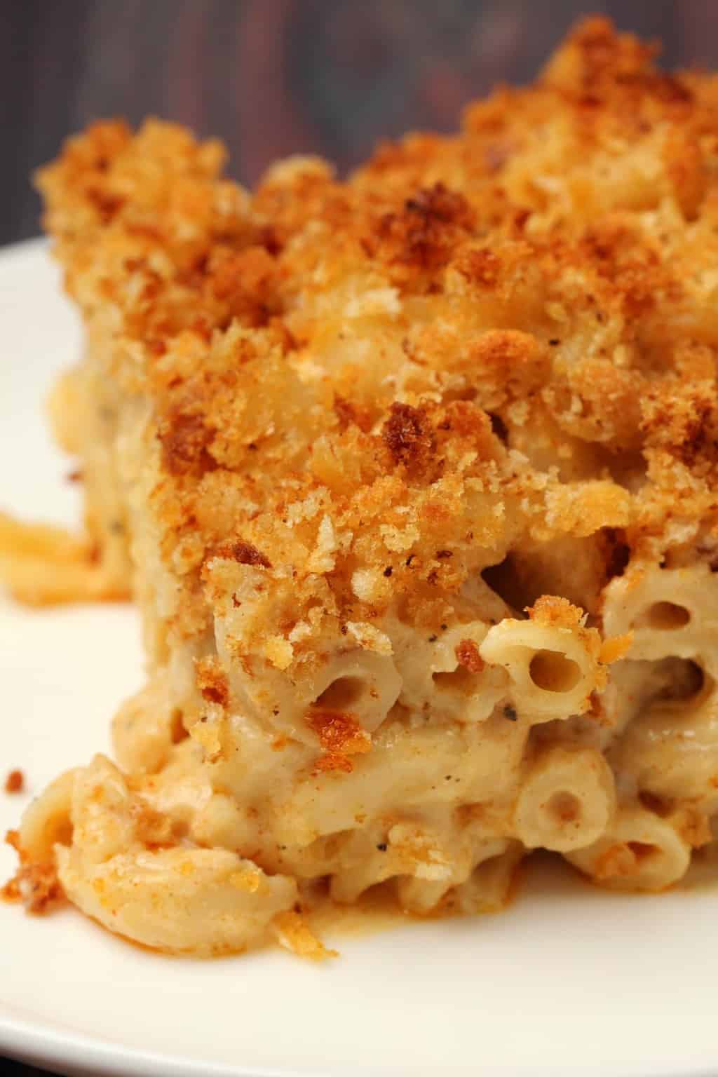 Macaroni au fromage végétalien au four Une tranche de mac et de fromage végétalien sur une plaque blanche.