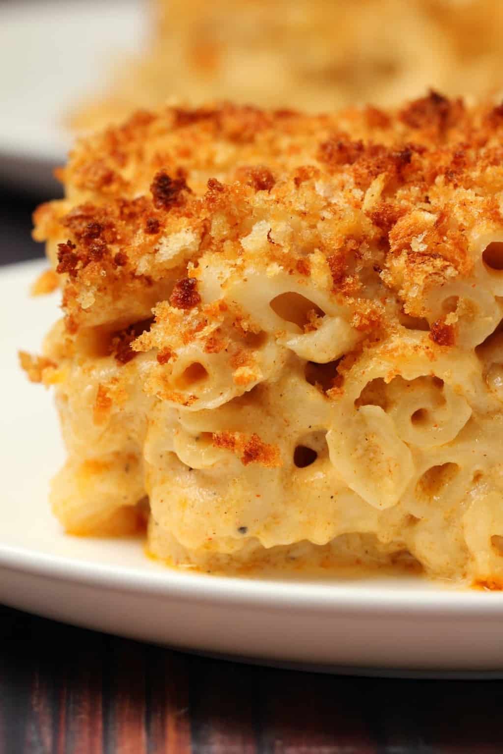 Macaroni au fromage végétalien au four Une tranche de mac et de fromage végétalien au four sur une plaque blanche.