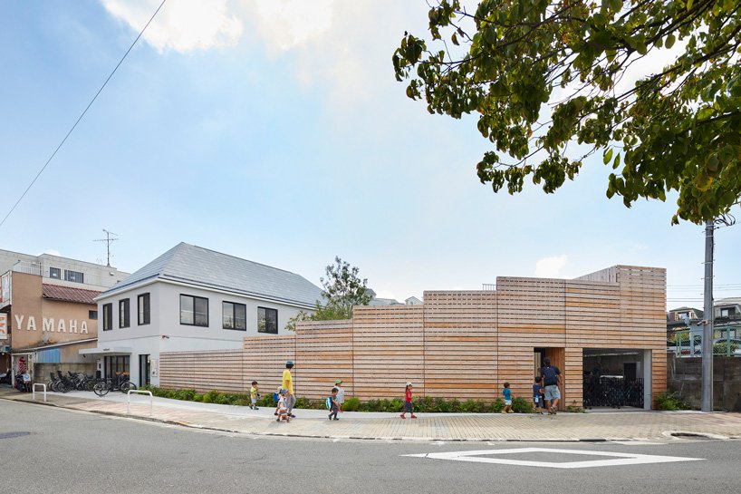 naf architect & design clôt une école maternelle de «petit étang» à tokyo avec une façade en bois courbé