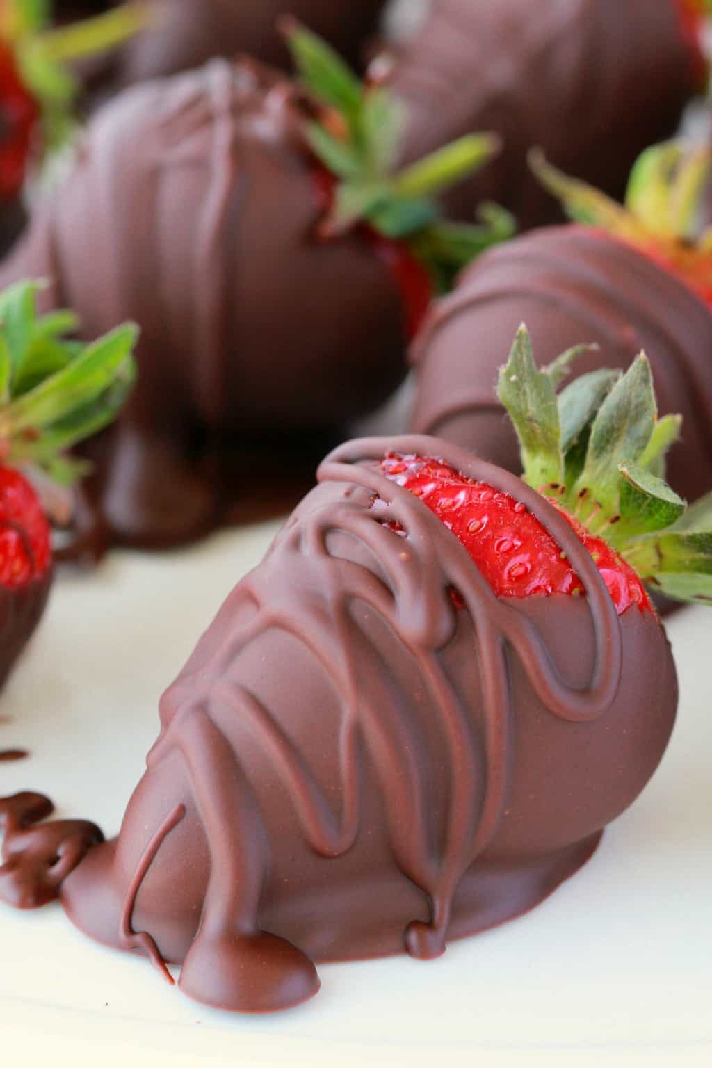Fraises enrobées de chocolat végétalien sur papier parchemin.