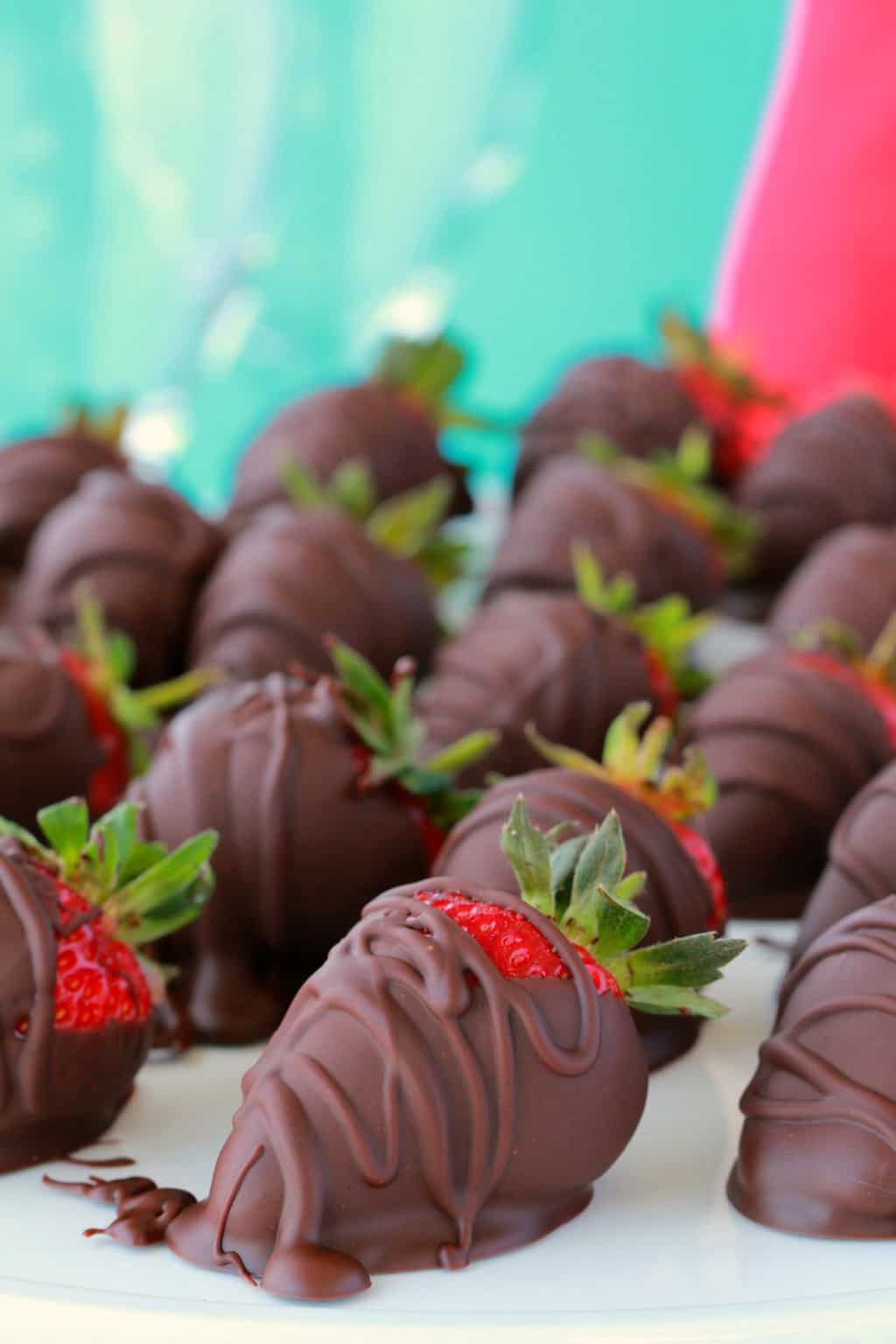 Fraises enrobées de chocolat végétalien sur papier parchemin.