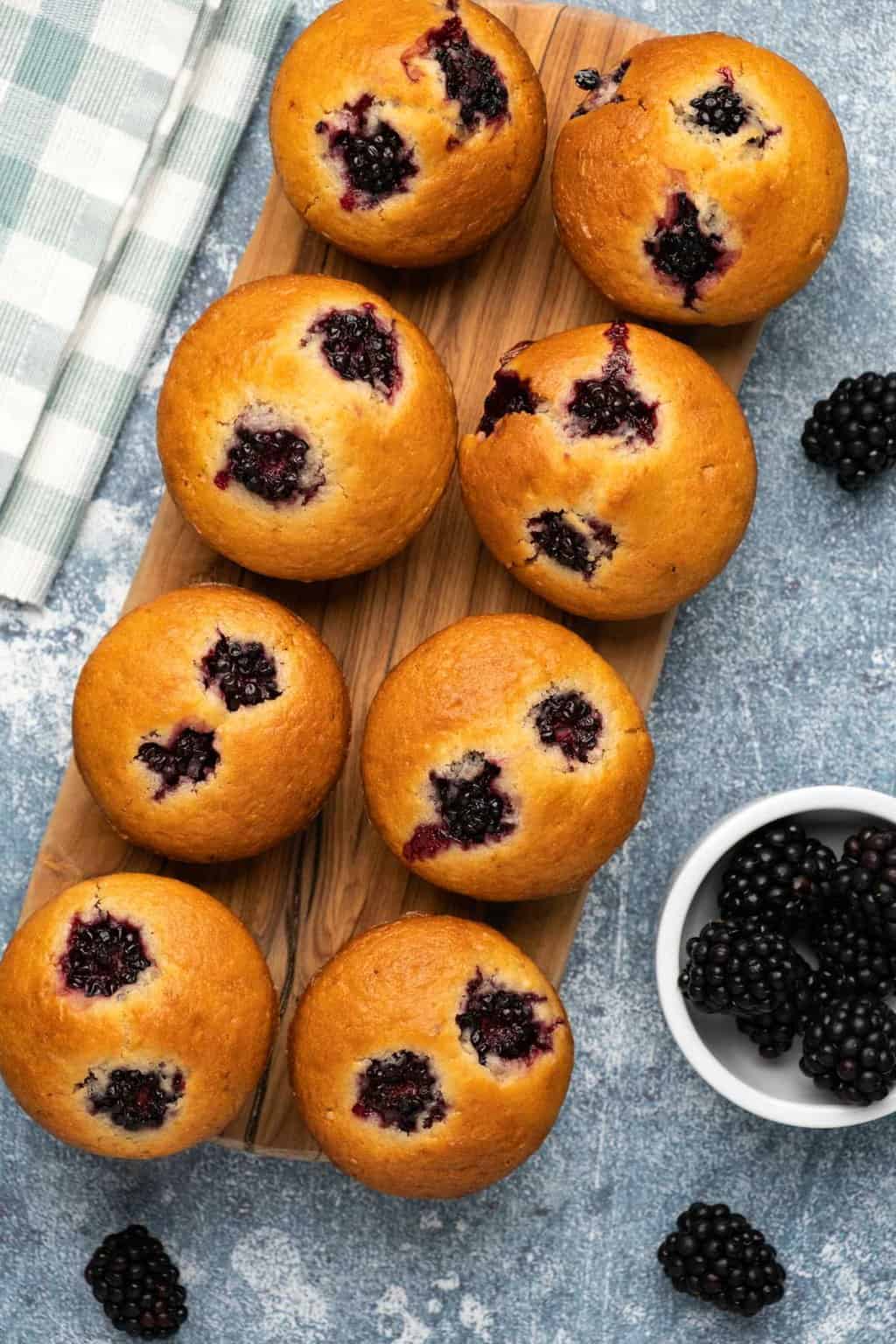 Muffins végétaliens aux mûres sur une planche de bois.