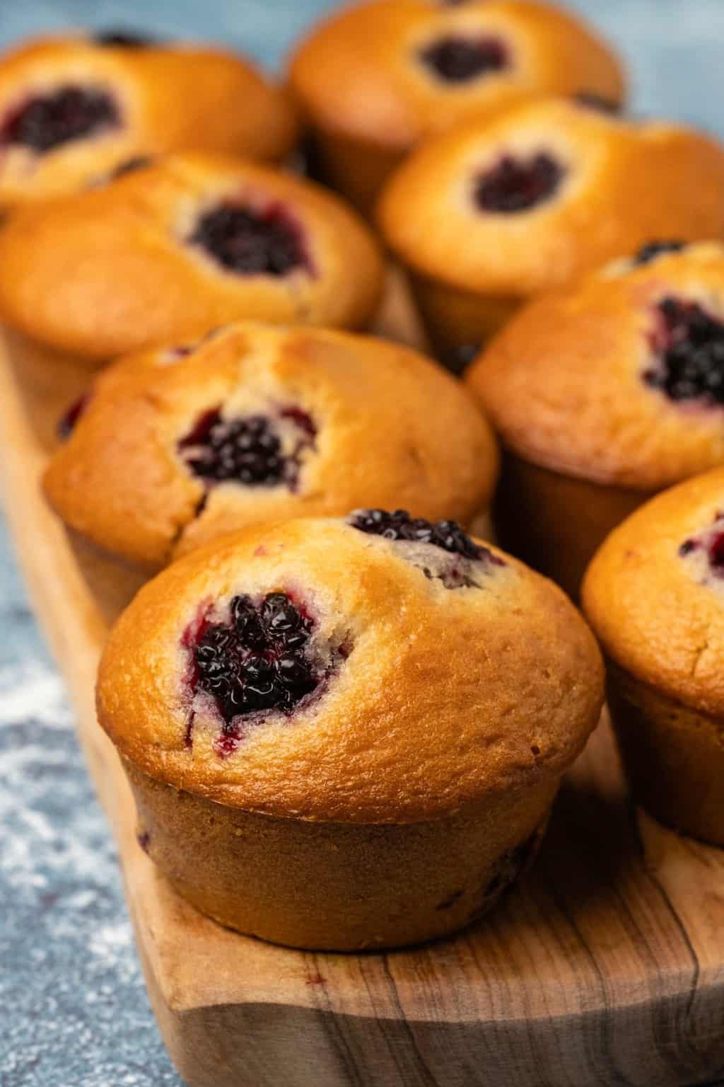 Muffins végétaliens aux mûres sur une planche de bois.