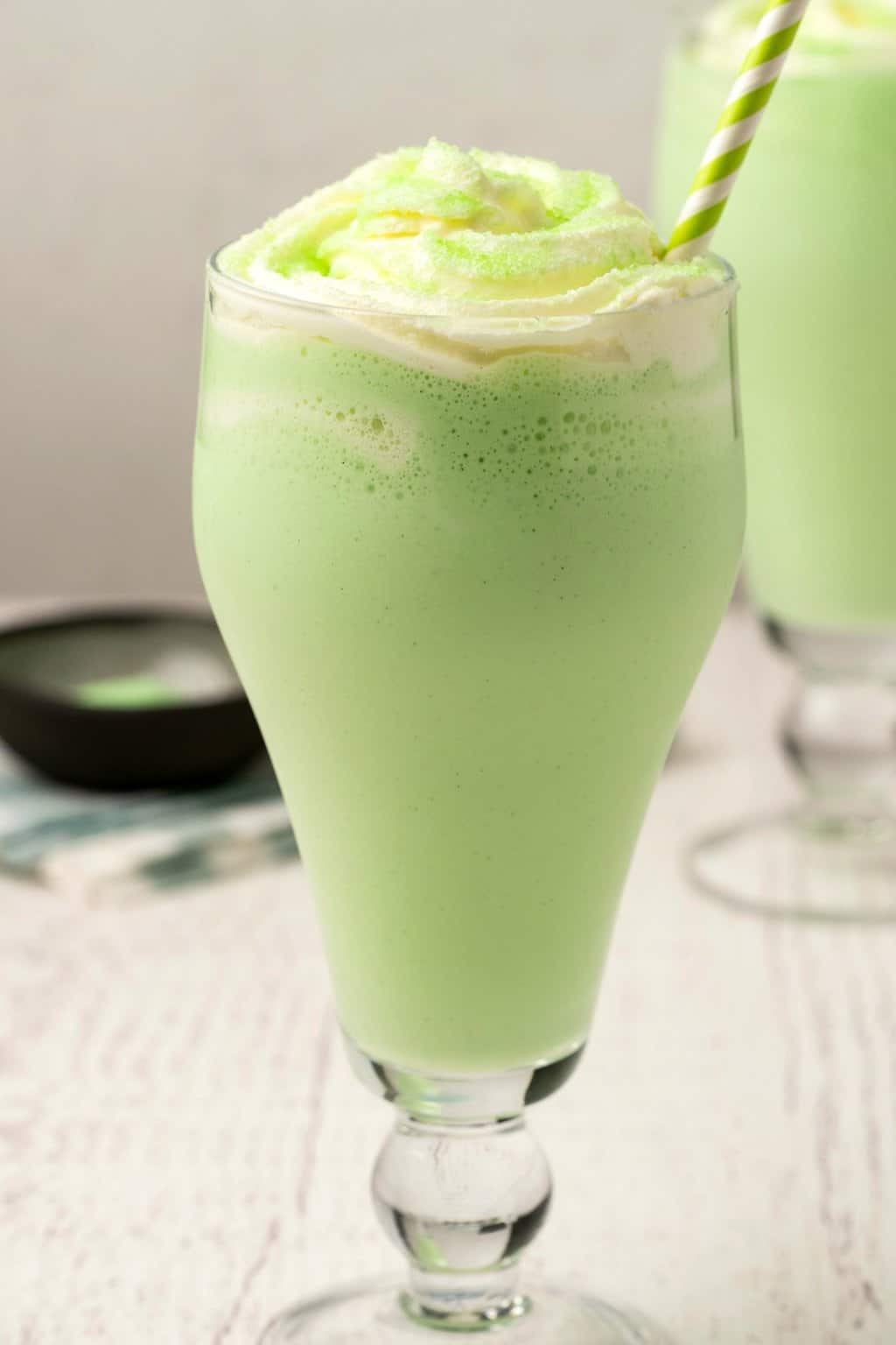 Shake de shamrock végétalien garni de crème fouettée et de sucre à poncer vert.