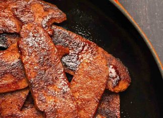 Bacon végétalien – Aimer végétalien Des lardons végétaliens dans une poêle.