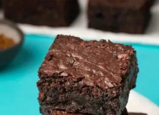 Brownies sans gluten végétaliens – Loving It Vegan Brownies sans gluten végétaliens en pile sur du papier sulfurisé blanc.