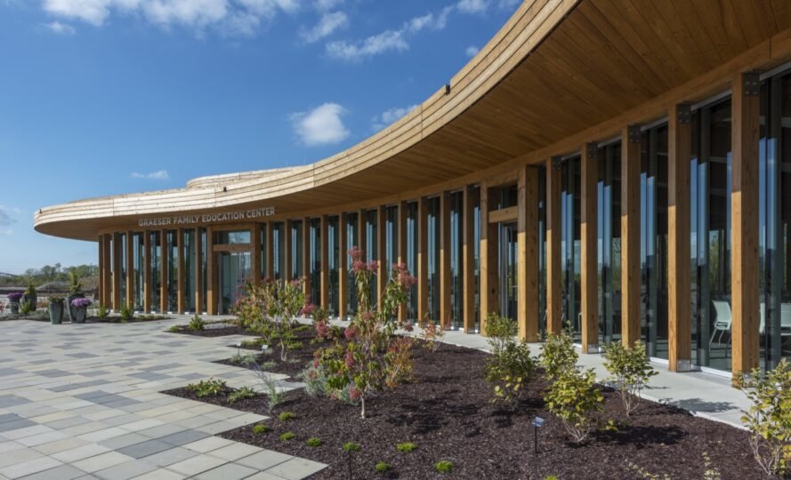 aménagement paysager frais et plantes devant un bâtiment en bois courbé