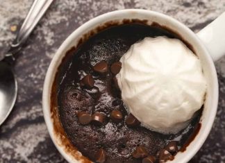 Gâteau de tasse végétalien – l’aimer végétalien Gâteau mug végétalien garni de crème végétalienne et de pépites de chocolat.