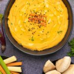 Houmous aux poivrons rouges rôtis – Recette sans gluten Houmous de poivron rouge rôti dans un bol noir.