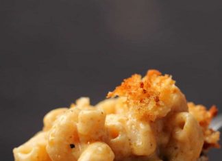 Le meilleur Mac et fromage végétalien (classique, au four) Une grande cuillerée de macaroni au fromage végétalien sortant d
