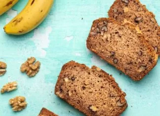 Pain aux bananes sans gluten végétalien Une miche de pain aux bananes végétalien sans gluten avec plusieurs tranches coupées.