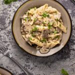 Pâtes aux champignons végétaliennes – Lilypop Pâtes aux champignons végétaliennes garnies de coriandre hachée dans un bol en pierre.