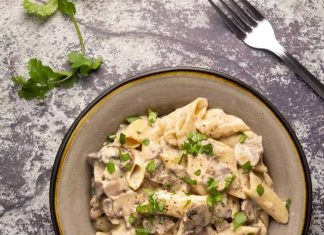 Pâtes aux champignons végétaliennes – Lilypop Pâtes aux champignons végétaliennes garnies de coriandre hachée dans un bol en pierre.