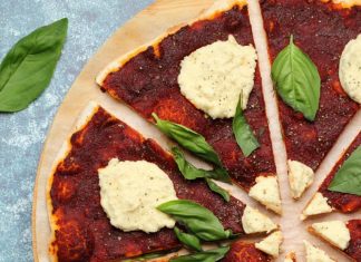 Recette de pizza végétalienne – croûte mince! Pizza végétalienne garnie de ricotta végétalienne et de feuilles de basilic frais.