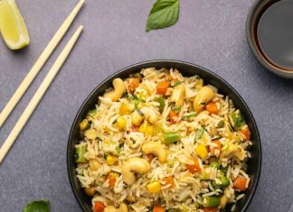 Riz frit végétalien – Aimer végétalien Riz frit végétalien dans des bols noirs avec des baguettes sur le côté.