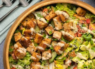 Salade de tofu mariné – Lilypop Salade de tofu arrosée de vinaigrette au tahini dans un saladier en bois.
