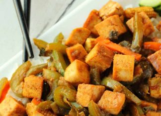 Sauté de tofu – Lilypop Sauté de tofu servi sur du riz sur une assiette blanche avec des baguettes.