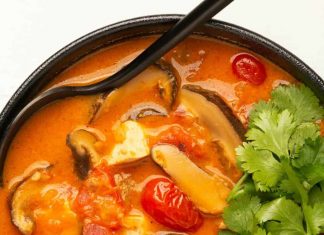 Soupe Tom Yum végétalienne – Aimer Vegan Soupe tom yum végétalienne à la coriandre fraîche dans un bol noir avec une cuillère.