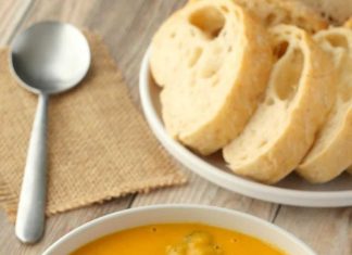 Soupe Vegan au Brocoli – Aimer Végétalienne Soupe de fromage au brocoli végétalien garnie de morceaux de brocoli et de fromage végétalien râpé dans un bol blanc.