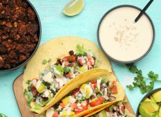 Tacos végétaliens – Lilypop Tacos végétaliens aux haricots noirs, viande taco végétalienne, pico de gallo, avocat et sauce tahini sur une planche de bois.