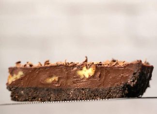 Tarte au chocolat végétalien (sans cuisson) – Loving It Vegan Une tranche de tarte au chocolat végétalienne sur un gâteau.