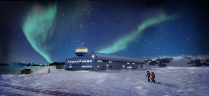 long bâtiment bleu dans le paysage enneigé de l'Antarctique sous une aurore dans le ciel
