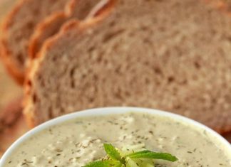 Tzatziki végétalien – l’aimer végétalien Tzatziki végétalien dans un bol blanc avec du pain de mie en arrière-plan.