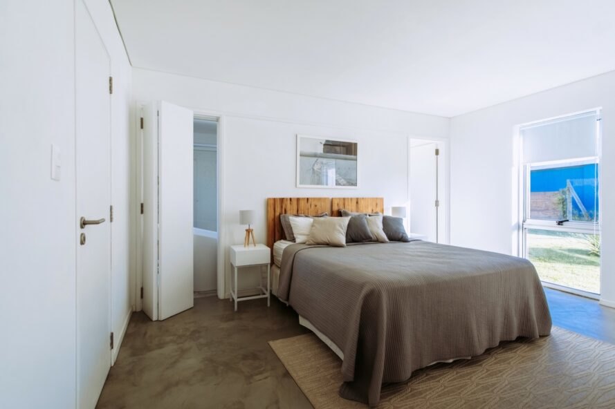 lit marron avec tête de lit en bois dans la chambre blanche