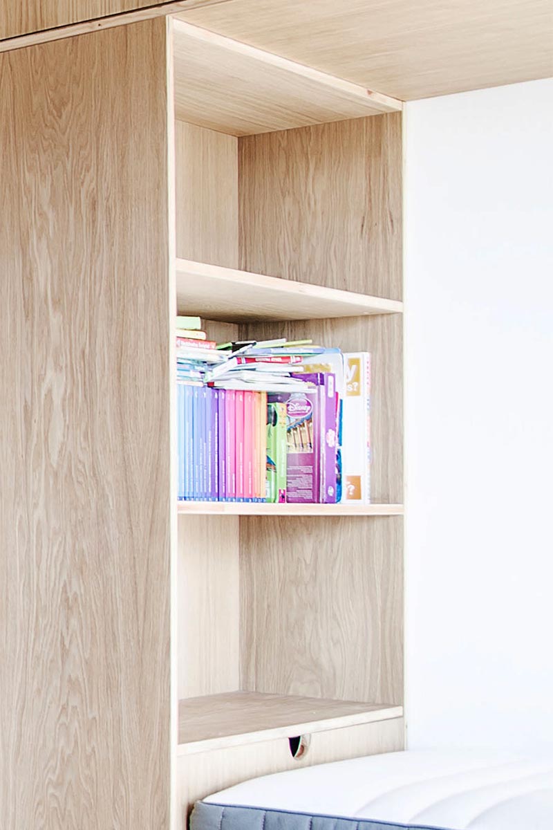 Chaque lit de ce lit superposé construit pour trois personnes a son propre espace de rangement dédié, où chaque enfant peut garder ses affaires facilement à portée de main au lit. #BunkBed #KidsBedroom #Shelving