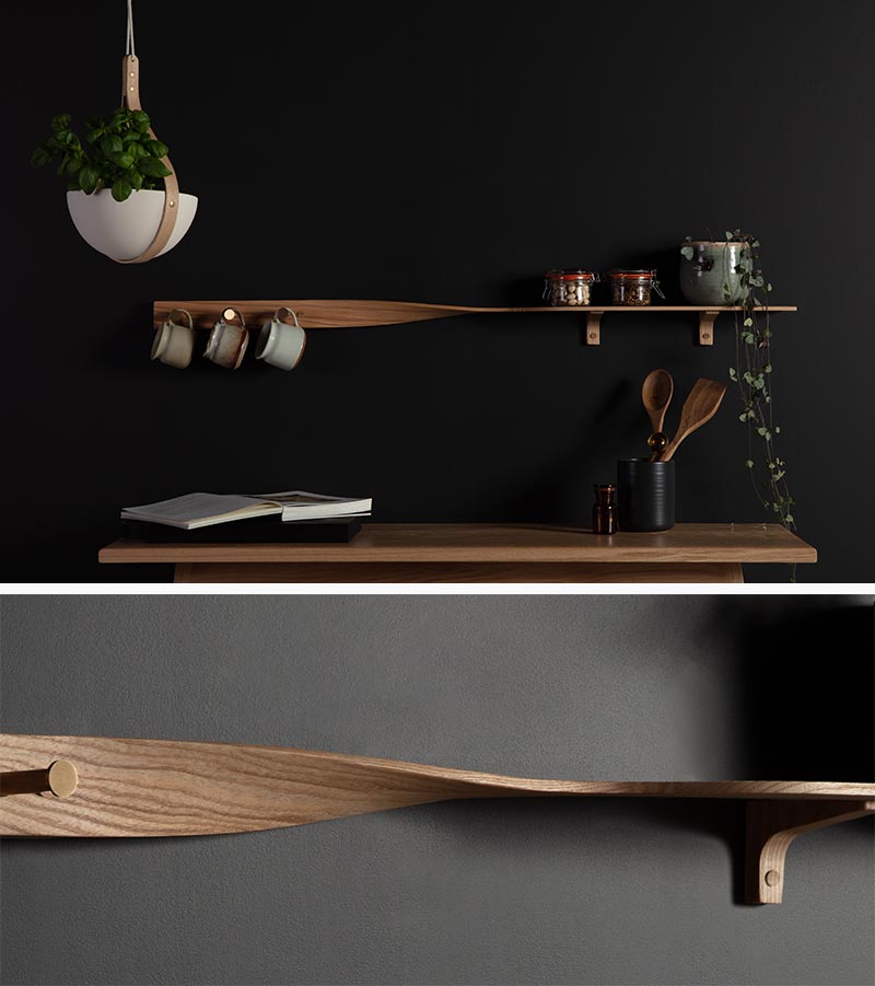 Soigneusement sculpté dans du bois de frêne ton sur ton, le Tor Twist Shelf se tord doucement au centre et s'élève au-dessus de trois patères en laiton brossé. #WoodShelving #WallShelf #ModernShelf #KitchenShelving #EntrywayShelf