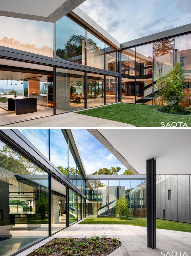 Des portes coulissantes en verre ouvrent cette cuisine moderne sur une cour intérieure en plein air. #Courtyard #GlassWalls