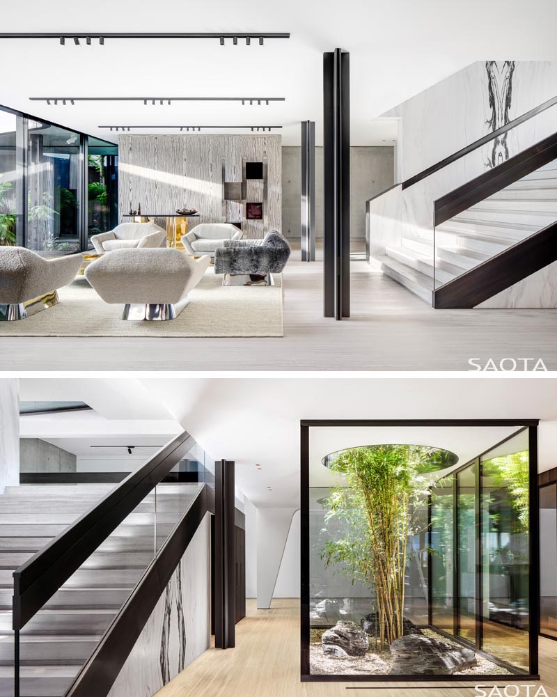 Cette maison moderne a un salon secondaire et un petit jardin intérieur entouré de verre, a un arbre qui a grandi à travers une ouverture circulaire. #InteriorGarden #LivingRoom #Stairs