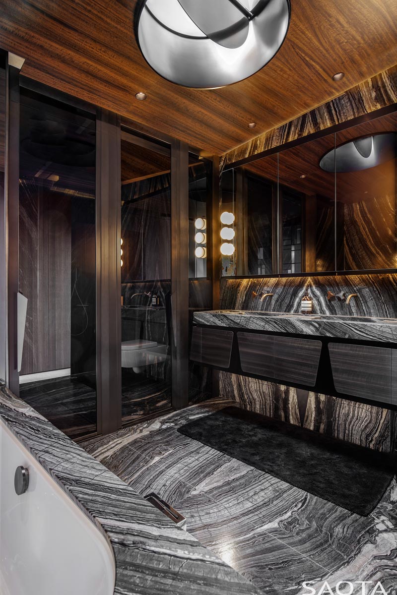 Cette salle de bains moderne présente des pierres noires et blanches et un riche plafond en bois. #ModernBathroom #Stone #WoodCeiling