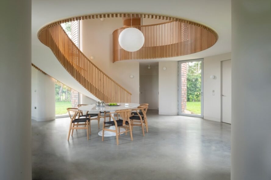 intérieur de la maison circulaire avec escalier en colimaçon et une petite table à manger