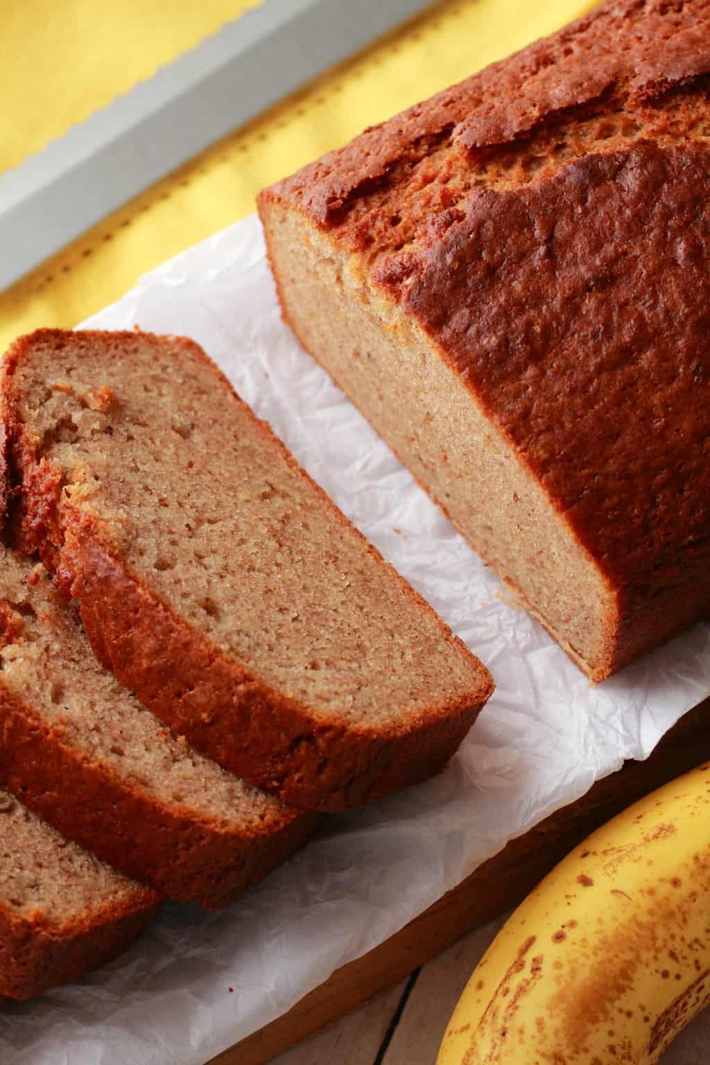 Pain aux bananes vegan tranché sur du papier sulfurisé.