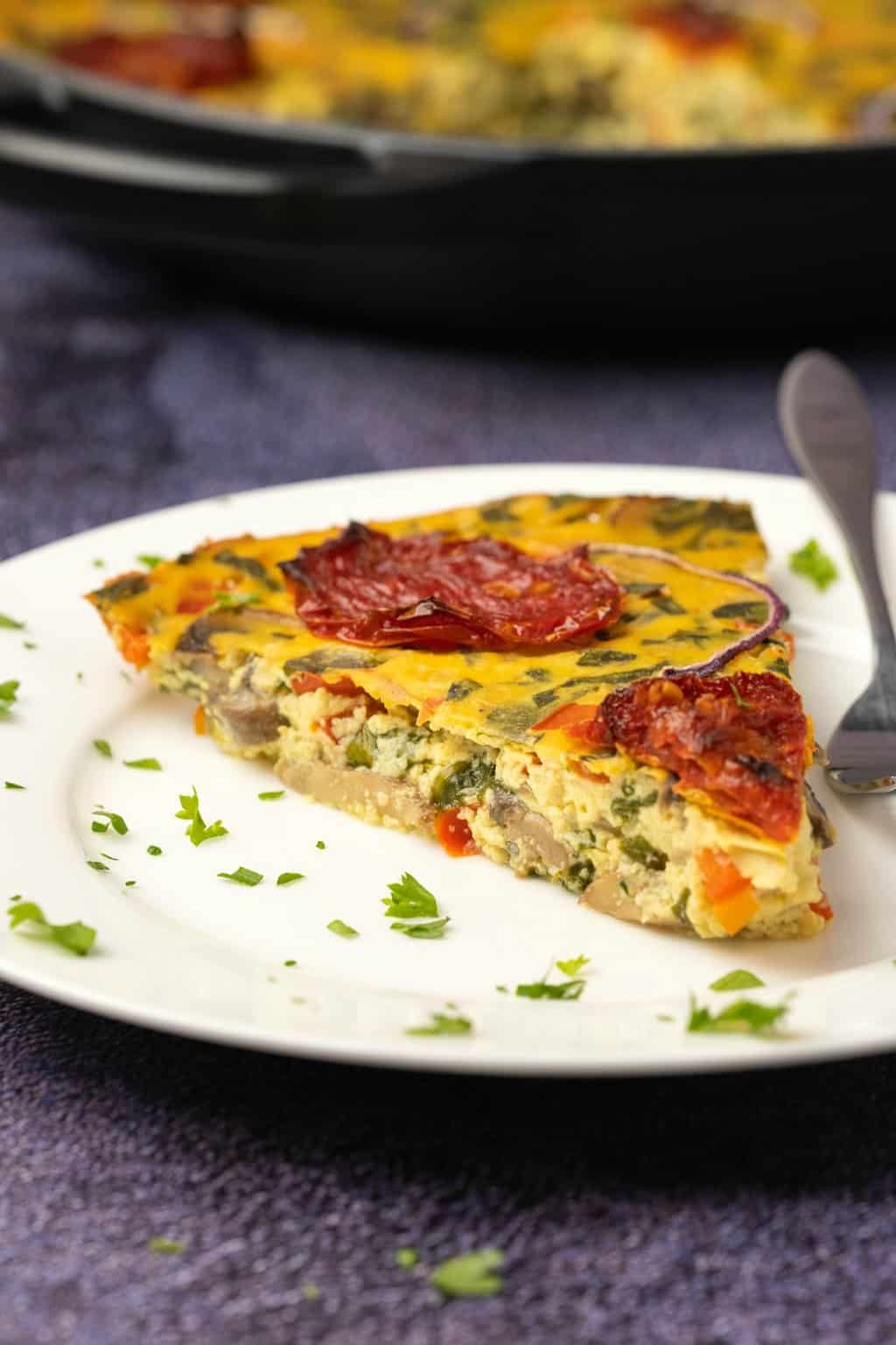 Tranche de frittata végétalienne sur une plaque blanche.
