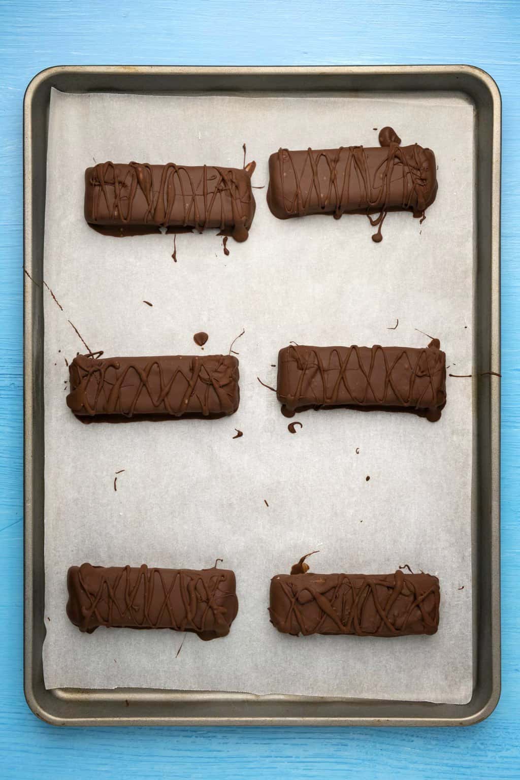 Barres de primes végétaliennes sur une plaque à pâtisserie tapissée de papier sulfurisé.