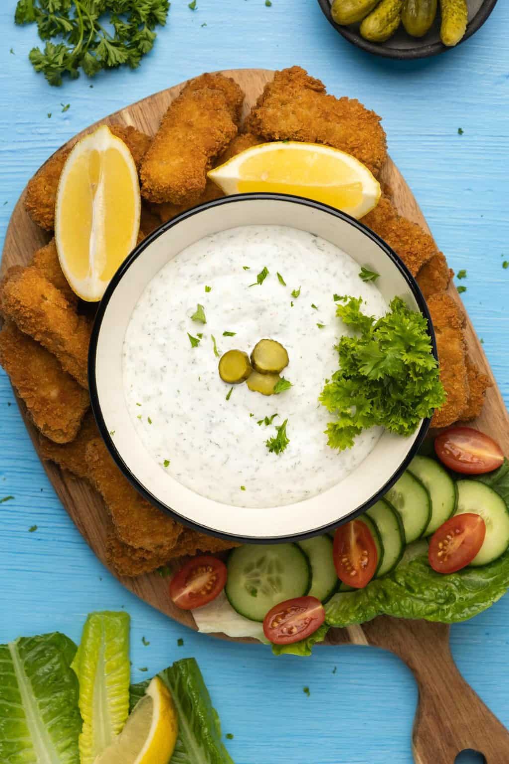 Sauce tartare végétalienne dans un bol en céramique garnie d'aneth tranché et de persil frais.