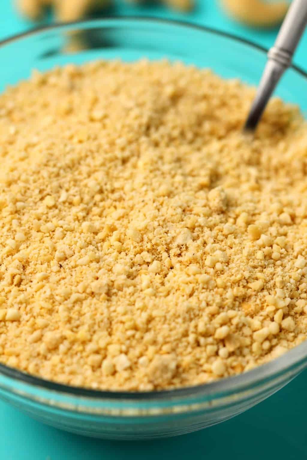 Fromage parmesan végétalien dans un bol en verre avec une cuillère.