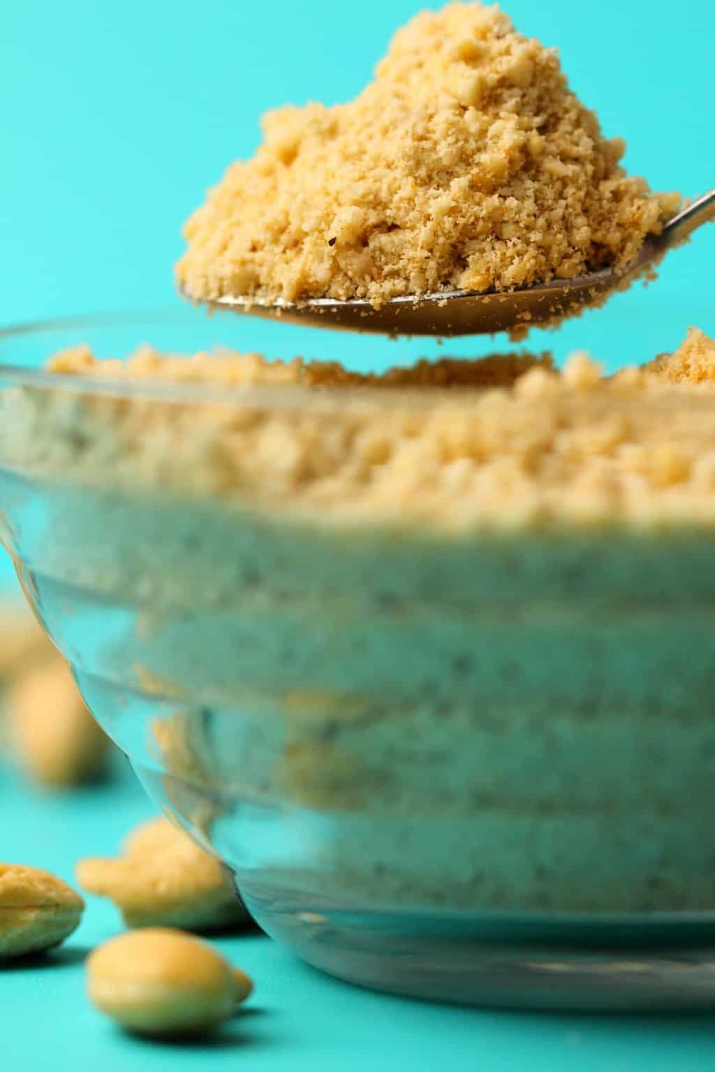 Fromage parmesan végétalien dans un bol en verre avec une cuillère.