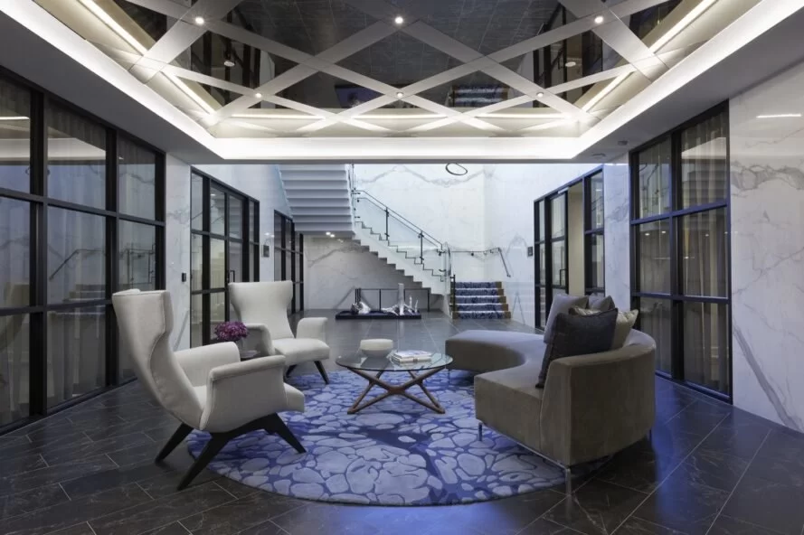 chaises blanches et canapé gris sous un plafond à motifs