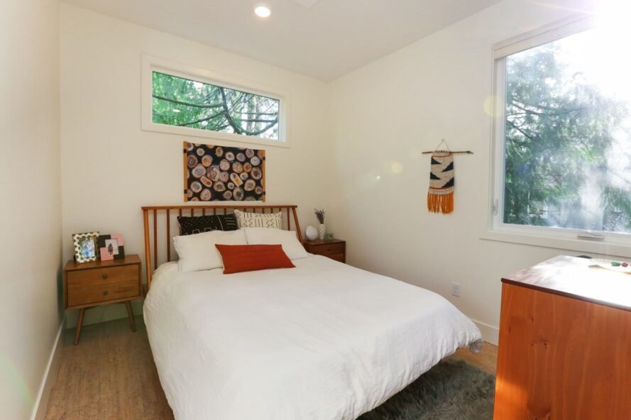 chambre avec lit blanc et grandes fenêtres