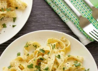 Sauce Alfredo végétalienne – Recette vegan Sauce Alfredo végétalienne et fettucine garnie de persil frais sur une plaque blanche.